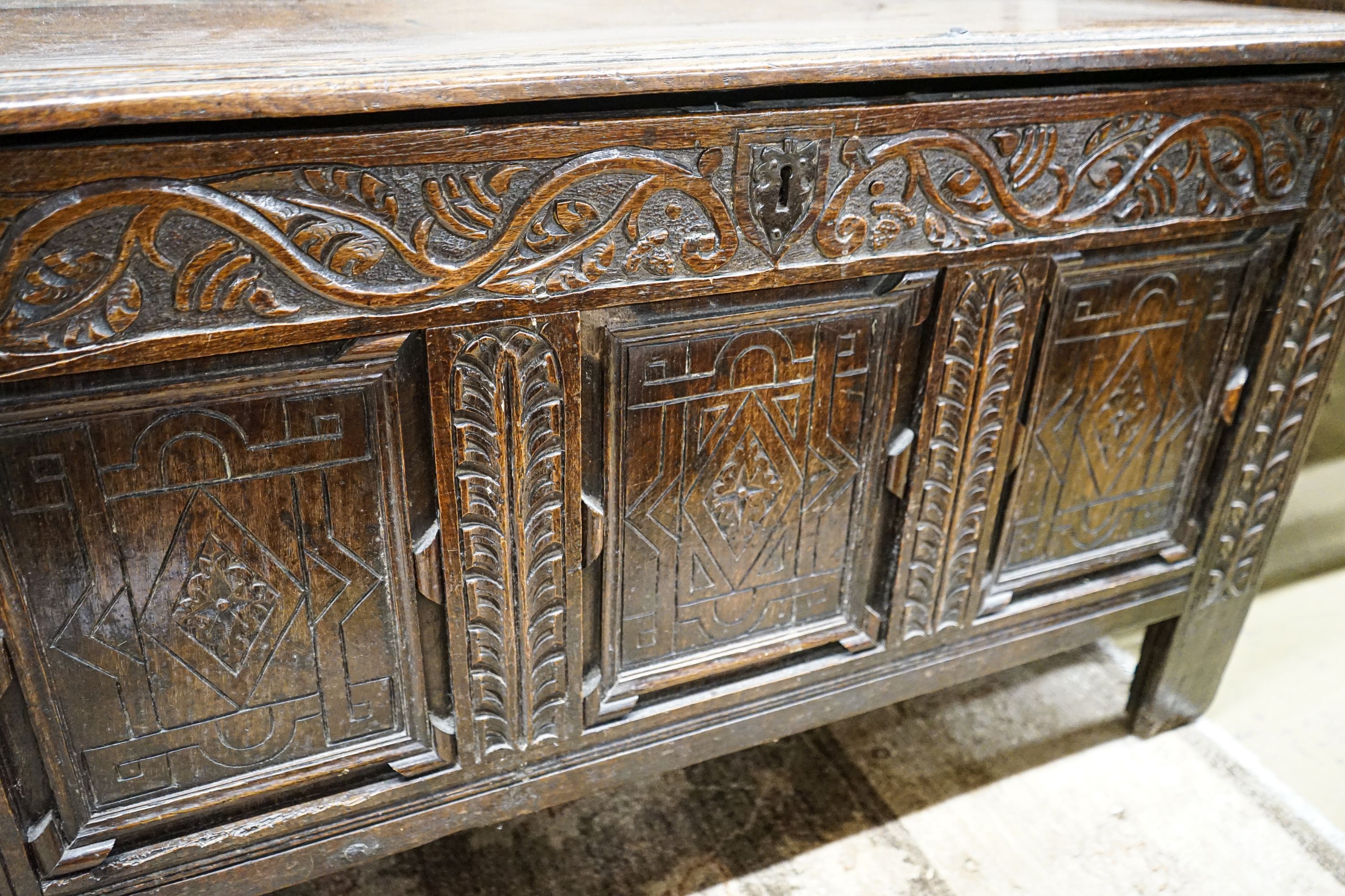 A 17th century oak coffer, with later carved front, length 120cm, depth 56cm, height 69cm